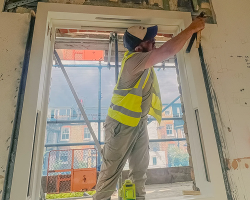 Worker fitting a window into an opening