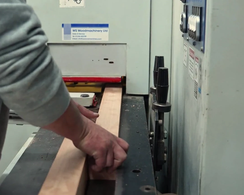 Craftsman shaping a timber sash rail on the moulder